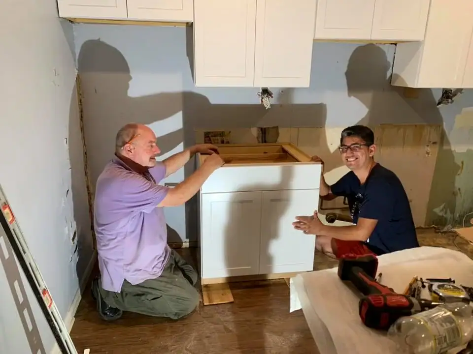 2 handyman installing kitchen cabinets